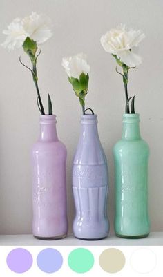 three different colored vases with flowers in them