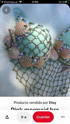 an ornament with seashells and pearls on it sitting in a net