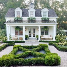 a white house with lots of greenery in the front yard