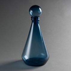 a blue glass vase sitting on top of a table