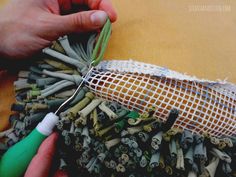 a person is sewing something on a piece of fabric with needles and thread in it