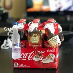 a coca - cola box with six bottles in it sitting on a table next to a christmas ornament