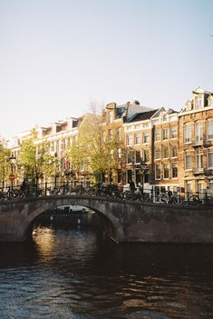 bicycles are parked on the side of a bridge over a body of water in front of some buildings