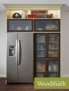 an american standard refrigerator in front of a bookshelf with glass doors and shelves