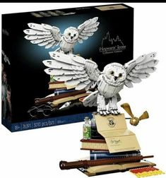 the harry potter owl is sitting on top of some books and has its wings spread out