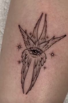 a small tattoo on the leg of a woman with an owl's eye and stars