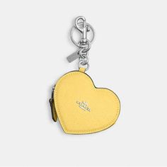 a small yellow heart shaped keychain on a white background