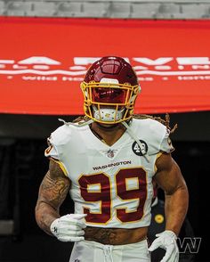 a football player wearing a helmet and holding his hands behind his back as he walks off the field