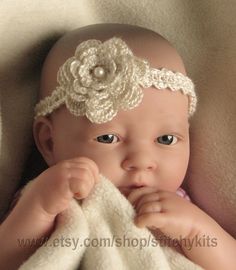 a baby wearing a white headband with a flower on it