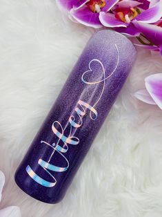 a purple and blue tumbler with the word fearless written on it next to flowers