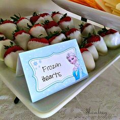 there are strawberries and other desserts on the table with a sign that says frozen hearts