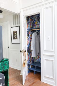 an open closet with clothes hanging on the wall and coat rack in front of it