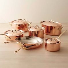 copper pots and pans on a wooden table