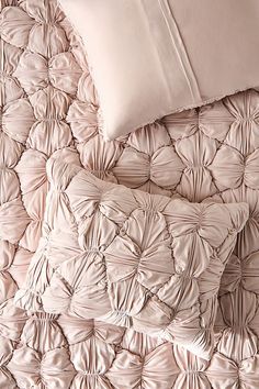 the comforter is made up with ruffled sheets and pillows