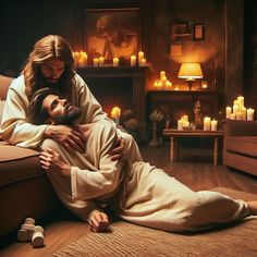 a man and woman laying on the floor next to each other with candles in the background