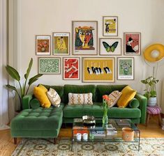 a living room with green couches and pictures on the wall