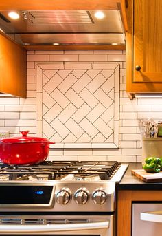 a stove top oven sitting inside of a kitchen next to wooden cabinets and counter tops