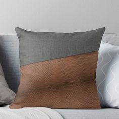 a brown and grey pillow sitting on top of a couch