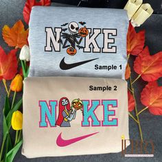 two t - shirts with cartoon characters on them sitting next to flowers and pumpkins