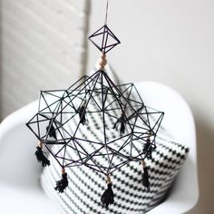 a black and white basket with tassels hanging from it's sides on a table