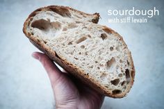 a person holding a piece of bread in their hand with the word sourdough written on it