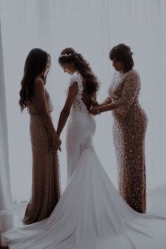 three women standing in front of a window with their hands on each other's hips