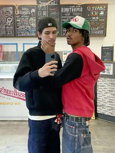 two young men standing next to each other in front of chalkboard menus on the wall