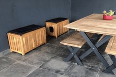 a wooden table with two benches and a potted plant on the side next to it