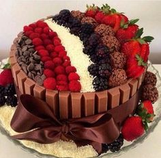 a chocolate cake with strawberries, raspberries and chocolates on the top