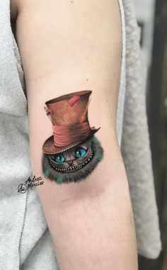 a cat with a top hat tattoo on the arm