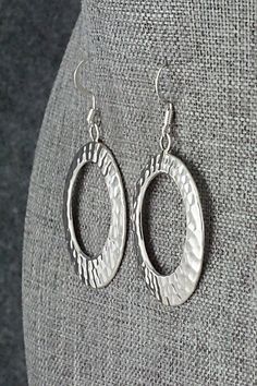 These sterling silver earrings were made by Navajo silversmith Pauline Nelson. The backs are signed N and stamped sterling.Length: 2"Width: 1 3/16"Free shipping on all orders! We ship with USPS and always include tracking. All orders ship within a day of payment.Returns are accepted up to 30 days after you receive your order. Just send us a message. Our shop offers cash back or store credit. The item must be returned in new condition. Artisan Silver Nickel-free Hoop Earrings, Silver Artisan Hoop Earrings Nickel Free, Artisan Sterling Silver Hypoallergenic Earrings, Artisan Hypoallergenic Sterling Silver Earrings, Nickel Free Silver Southwestern Earrings, Hammered Sterling Silver Oval Jewelry, Silver Southwestern Style Earrings For Gifting, Silver Southwestern Hoop Earrings As Gift, Silver Southwestern Earrings For Gift