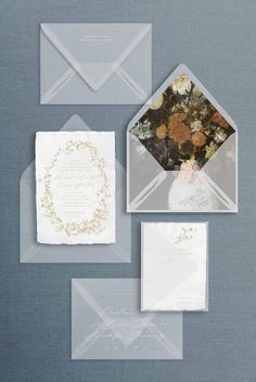 wedding stationery with envelopes and flowers on the inside, along with an ornament