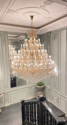 a large chandelier hanging from the ceiling in a room with white walls and flooring