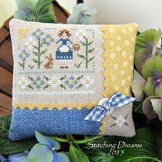 a blue and yellow pillow sitting on top of a wooden chair next to green plants