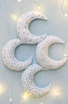 three crescents are made out of fabric and string lights