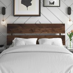 a bed with white sheets and pillows in a bedroom next to pictures on the wall