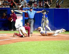 a baseball player sliding into home plate during a game