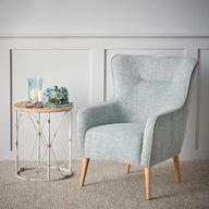 a white chair sitting next to a small table on top of a carpeted floor