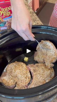 someone is using a spoon to cut up some meat in the slow cooker and then put it in the crock pot