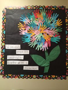 a bulletin board with handprints and flowers on it