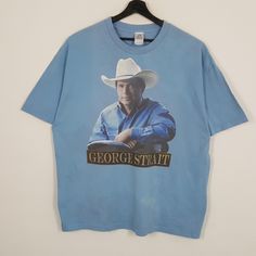 a blue t - shirt with an image of a man wearing a cowboy hat on it