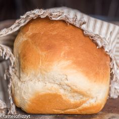 a loaf of bread wrapped in paper sitting on top of a table