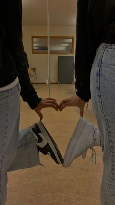 two people holding hands in the shape of a heart