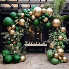 an archway decorated with green and gold ornaments in front of a table set up for a party