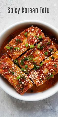 spicy korean tofu in a white bowl with sesame seeds