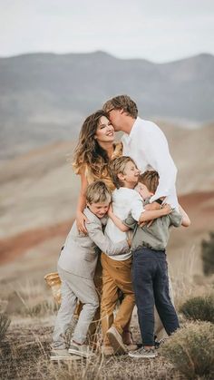 a family hugging each other on top of a hill