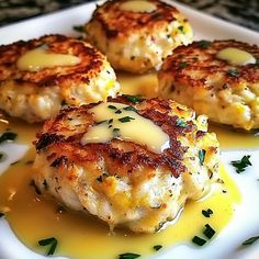 three crab cakes on a white plate with sauce