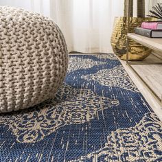 a blue and white rug sitting on top of a wooden floor next to a window