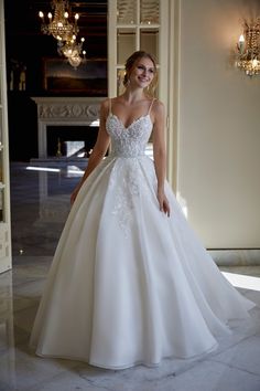 a woman in a white wedding dress posing for the camera