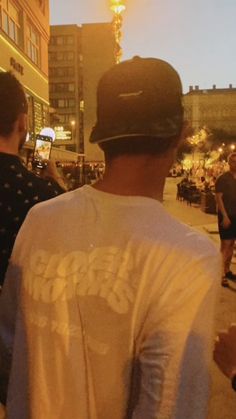 a group of men standing around each other in front of a building at night time